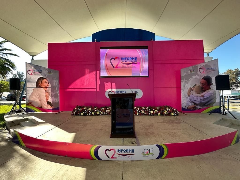 Escenario montado con pantalla de proyección en un evento del grupo